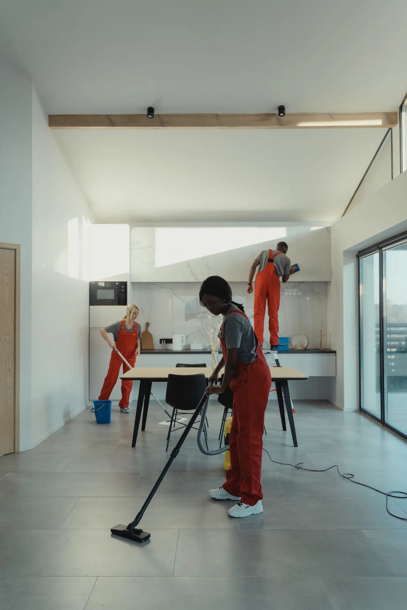 Professional cleaner vacuuming a bright modern home